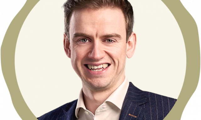 Picture shows white man in corporate clothes, smiling to camera