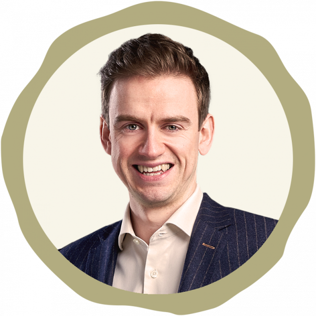Picture shows white man in corporate clothes, smiling to camera