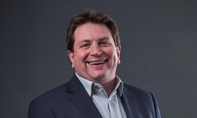 Haydn Jones Planning Director smiling infront of grey screen