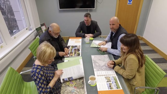 Landowners and Richborough team members sat around a table in the Richborough office looking through brochures.