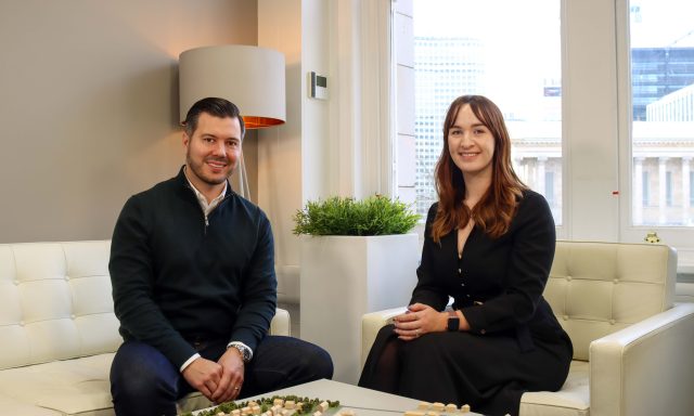 Man and woman seated in office smiling