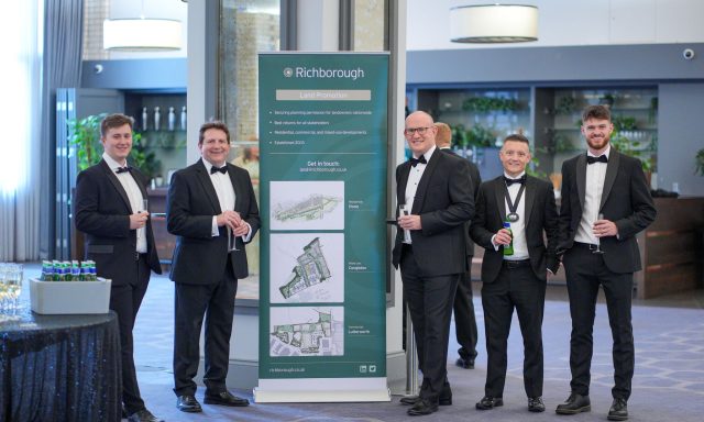 Picture shows five Richborough employees in black tie around a pull up banner showcasing Richborough at the RTPI awards