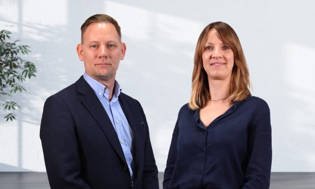 A man and woman stood side by side in corporate dress