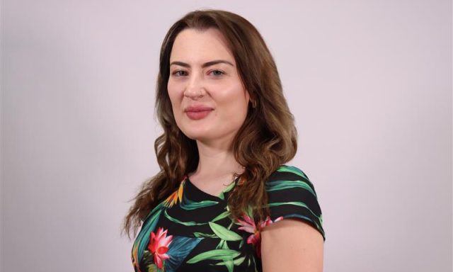 Image shows young while lady smiling into camera