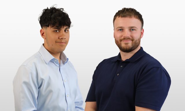 Two men smile for the camera